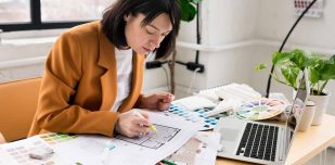 Architecture and interior design concept. Young businesswoman architect choosing materials and details for creating interior design project in studio. Freelancer woman working in a modern office